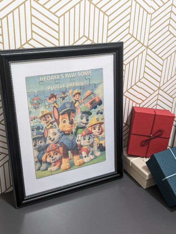 Framed Paw Patrol wooden puzzle keepsake displayed against a patterned wall.